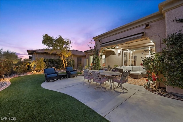 patio terrace at dusk featuring a yard and an outdoor hangout area