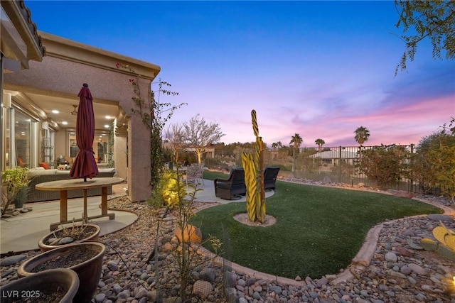 yard at dusk featuring a patio area