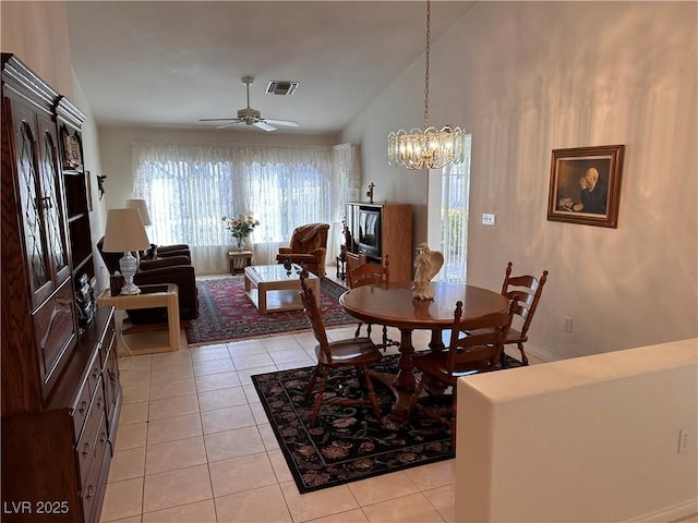 dining space featuring light tile patterned flooring, lofted ceiling, and ceiling fan with notable chandelier