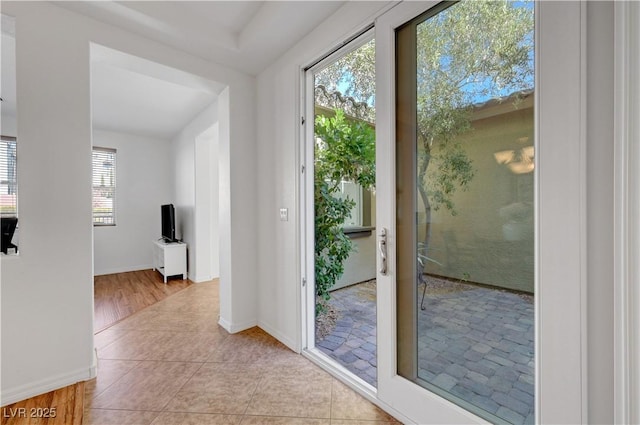 doorway featuring a healthy amount of sunlight and light tile patterned flooring