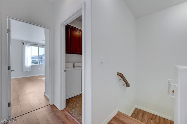 hallway with light wood-type flooring and washer and dryer