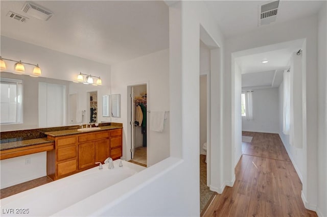 bathroom featuring toilet, wood-type flooring, and vanity