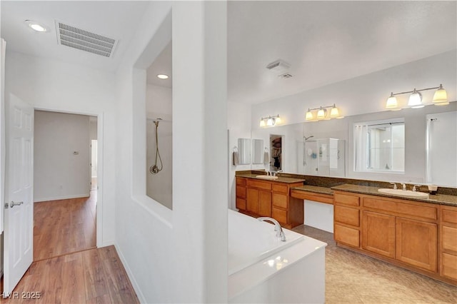 bathroom with hardwood / wood-style floors, vanity, and independent shower and bath