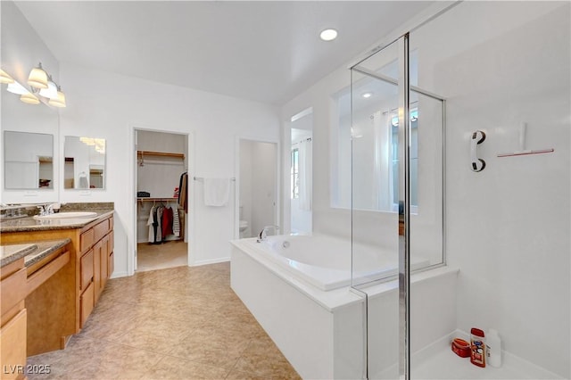 bathroom featuring independent shower and bath, tile patterned floors, and vanity