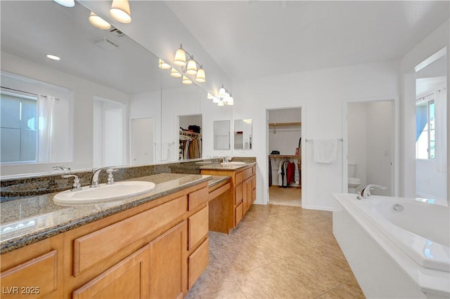 bathroom with toilet, vanity, and tile patterned floors