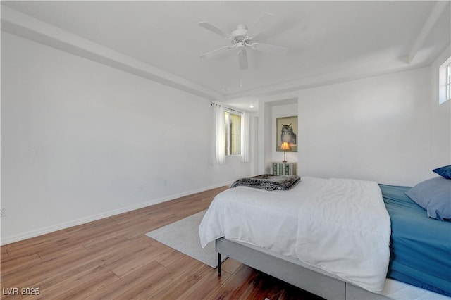 bedroom with ceiling fan, radiator, and light wood-type flooring