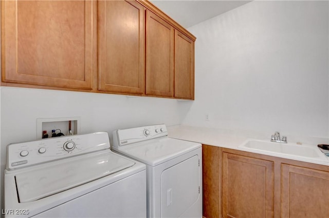 washroom featuring washer and clothes dryer, sink, and cabinets