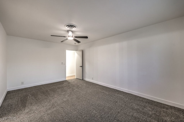 empty room with ceiling fan and dark carpet