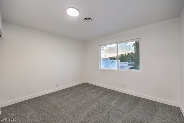 unfurnished room featuring dark colored carpet