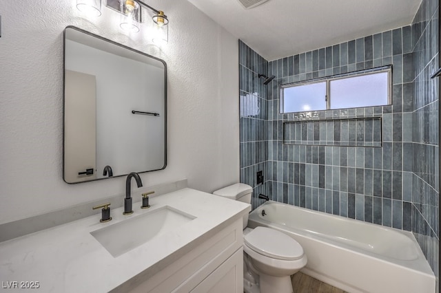 full bathroom with toilet, tiled shower / bath combo, and vanity