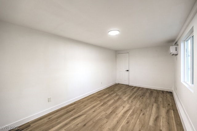 unfurnished room featuring an AC wall unit and wood-type flooring