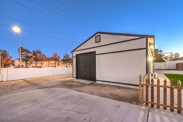 view of garage at dusk