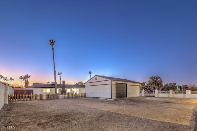 view of garage at dusk