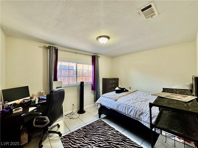 tiled bedroom featuring a textured ceiling