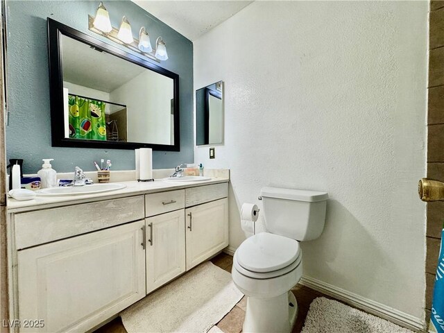 bathroom featuring toilet, vanity, tile patterned flooring, and walk in shower