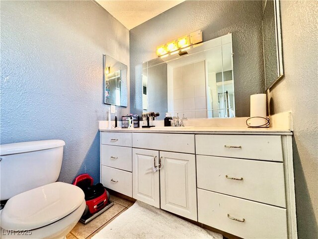 bathroom featuring toilet, vanity, and tile patterned floors