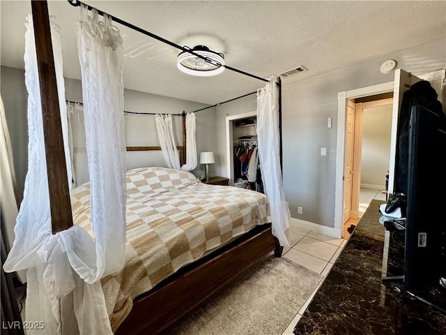 bedroom with a closet, a spacious closet, and a textured ceiling