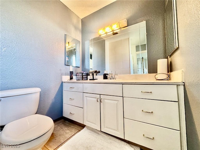 bathroom featuring vanity, tile patterned floors, and toilet