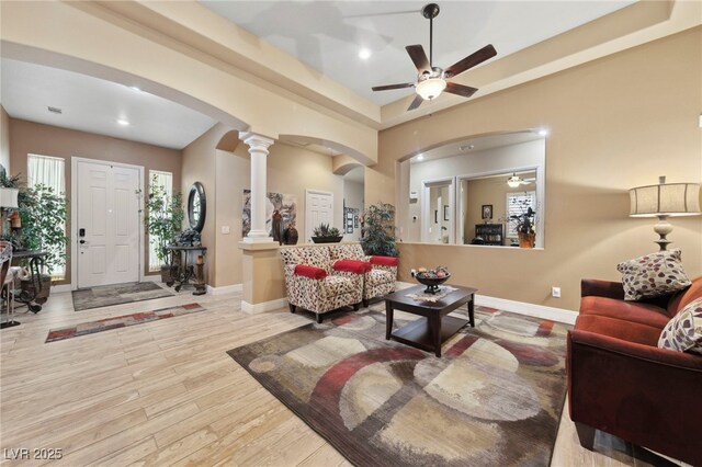 living room featuring decorative columns, light hardwood / wood-style flooring, and ceiling fan