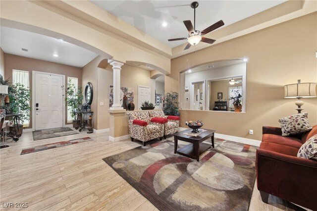 10372 Hawks Wing St, Las Vegas, NV 89178 - living room with decorative columns, ceiling fan, a raised ceiling, and light hardwood / wood-style floors