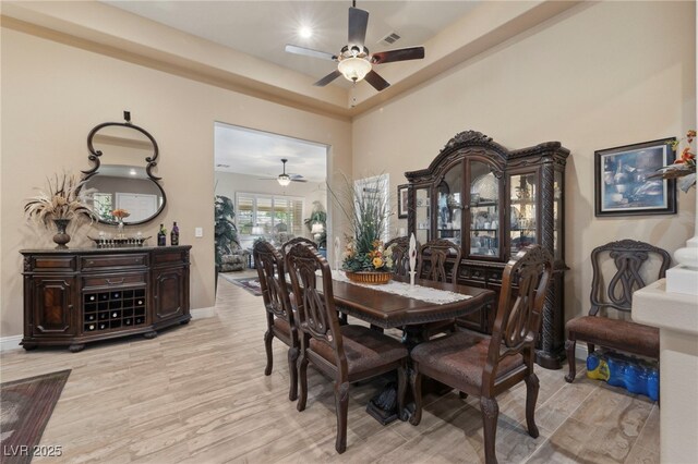 10372 Hawks Wing St, Las Vegas, NV 89178 - dining area featuring ceiling fan, a tray ceiling, and light wood-type flooring
