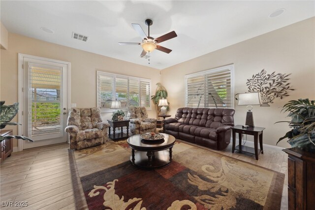 living room featuring ceiling fan, a wealth of natural light, and light hardwood / wood-style flooring