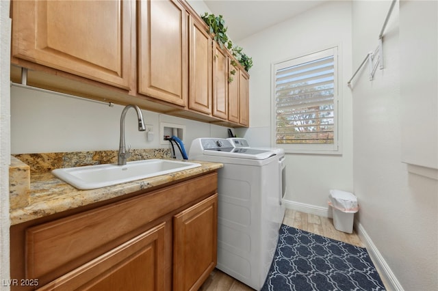 10372 Hawks Wing St, Las Vegas, NV 89178 - clothes washing area featuring sink, light hardwood / wood-style flooring, cabinets, and washing machine and clothes dryer