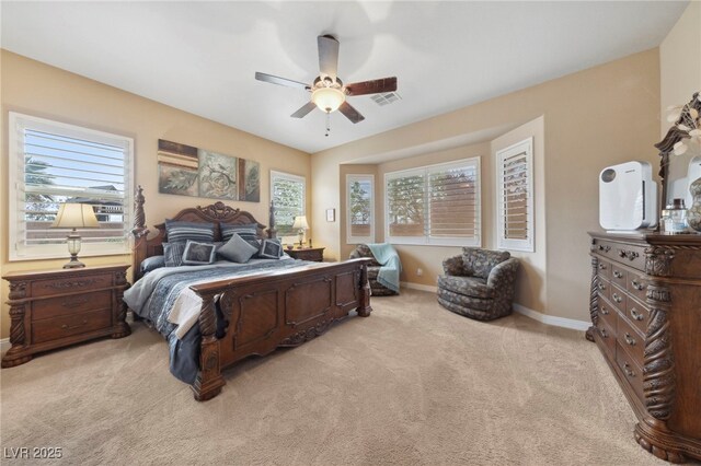 bedroom featuring ceiling fan, light colored carpet, and multiple windows