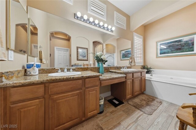 bathroom featuring vanity, a bathing tub, and hardwood / wood-style floors