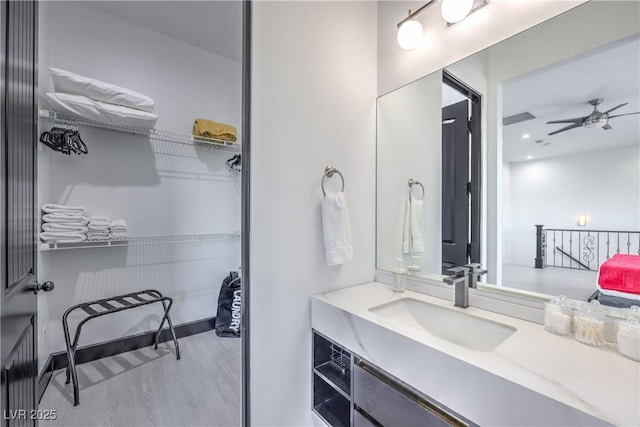 bathroom with ceiling fan, wood-type flooring, and vanity