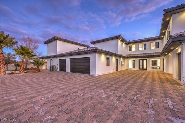 view of front of property featuring a garage and central air condition unit