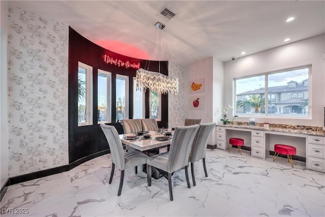 dining space featuring built in desk and a chandelier