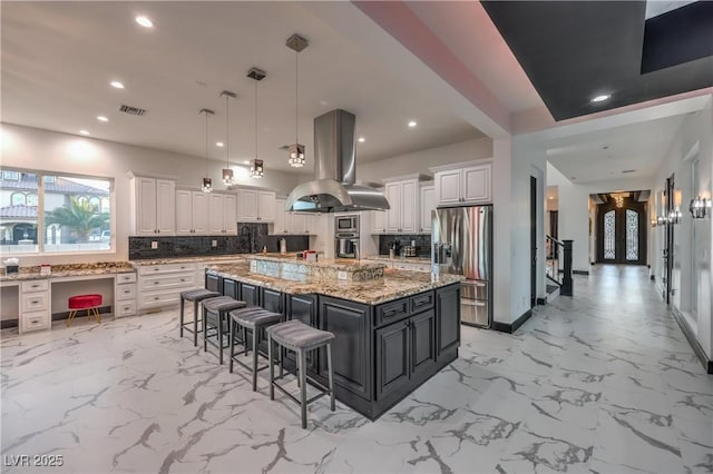 kitchen featuring white cabinetry, island exhaust hood, stainless steel appliances, a spacious island, and pendant lighting