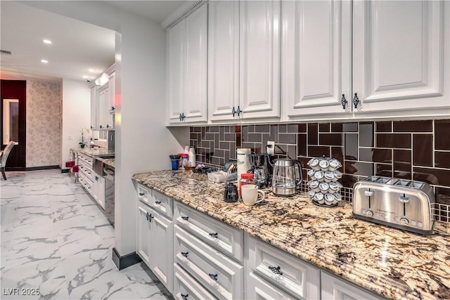 kitchen with backsplash, white cabinets, and light stone counters