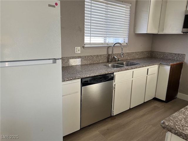 kitchen with white refrigerator, dishwasher, white cabinetry, and sink