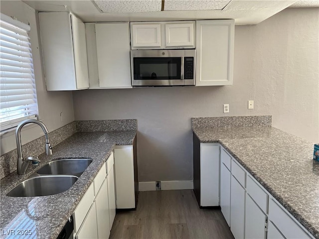 kitchen featuring dark hardwood / wood-style floors, a healthy amount of sunlight, white cabinets, and sink