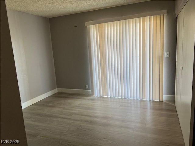 unfurnished room featuring a textured ceiling and hardwood / wood-style floors