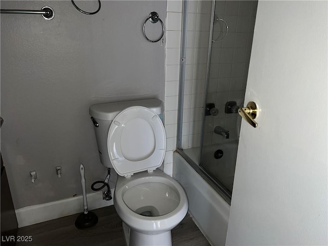 bathroom featuring toilet, combined bath / shower with glass door, and hardwood / wood-style flooring