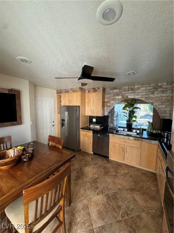 kitchen with ceiling fan, light brown cabinets, stainless steel appliances, and a textured ceiling