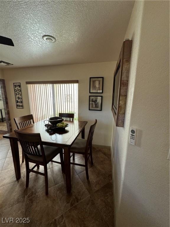 tiled dining area with a textured ceiling