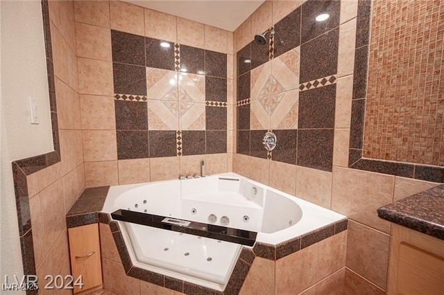 bathroom with a relaxing tiled tub, tile walls, and vanity