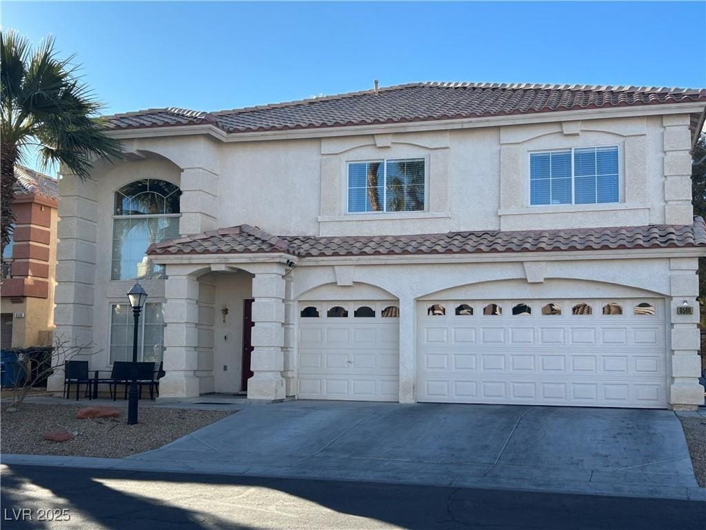 mediterranean / spanish home featuring a garage