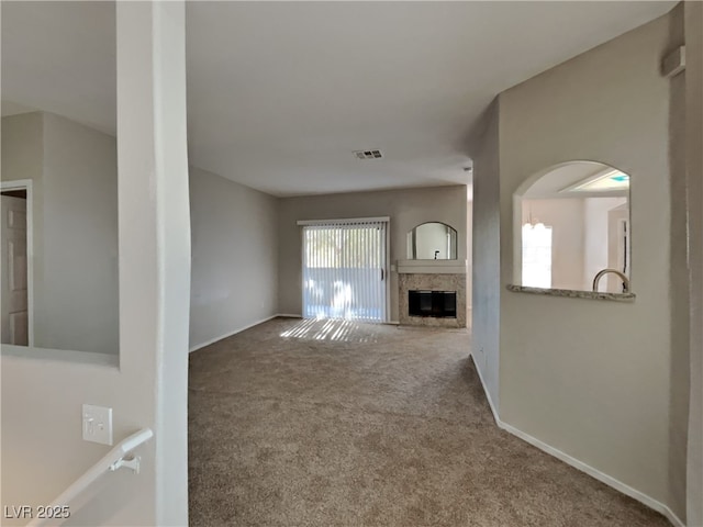 unfurnished living room with carpet floors and a fireplace