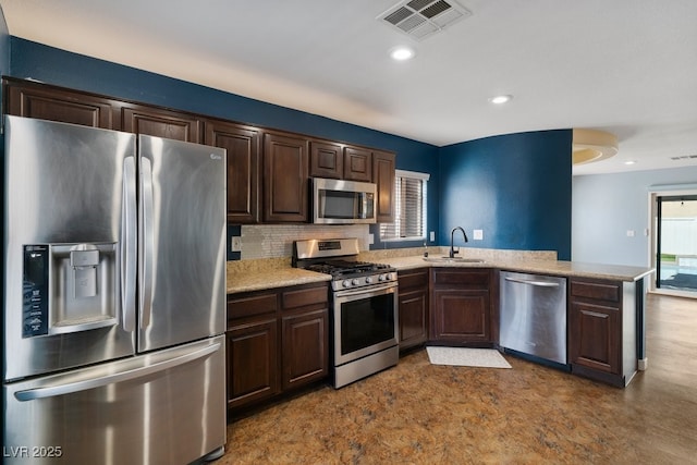 kitchen with plenty of natural light, kitchen peninsula, sink, and stainless steel appliances