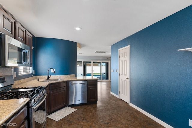 kitchen featuring stainless steel appliances, dark brown cabinetry, and sink