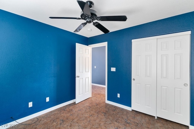 unfurnished bedroom with ceiling fan, dark carpet, and a closet