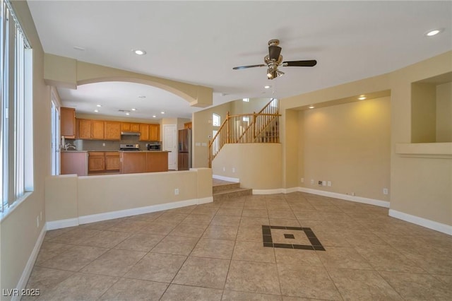 unfurnished living room with light tile patterned floors, recessed lighting, stairs, and baseboards