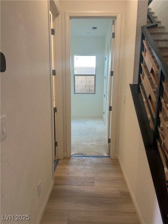 corridor with light hardwood / wood-style floors