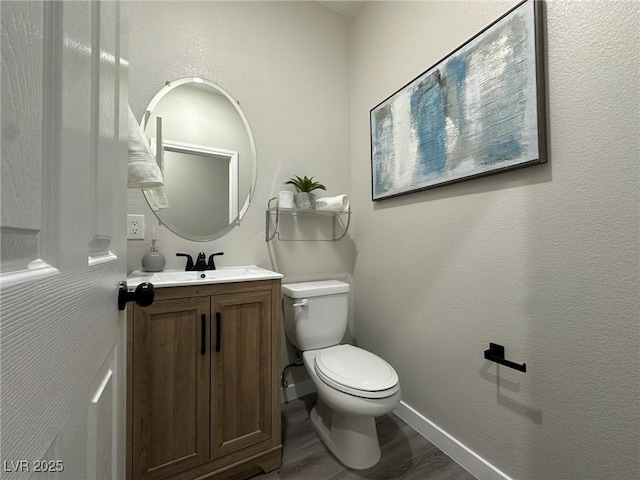 bathroom featuring toilet, vanity, and wood-type flooring