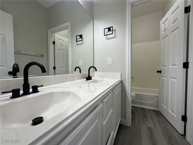 full bathroom with toilet, tub / shower combination, hardwood / wood-style floors, and vanity